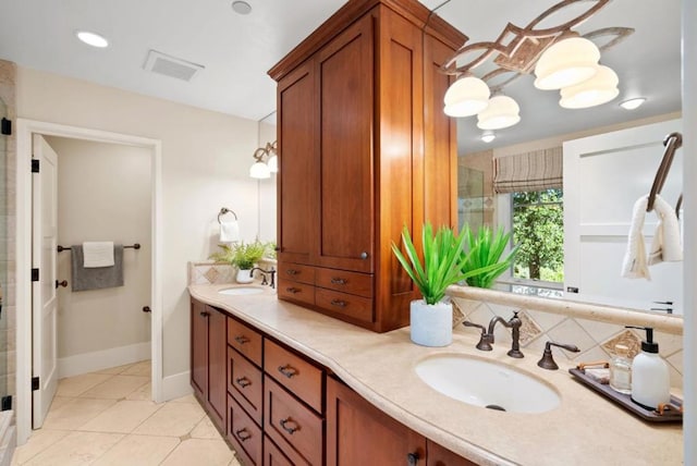 bathroom with a shower with shower door, tile patterned floors, and vanity