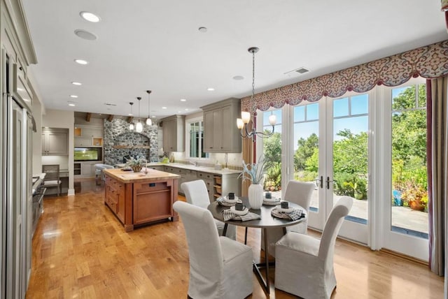 dining area featuring a healthy amount of sunlight, a chandelier, and light wood-type flooring