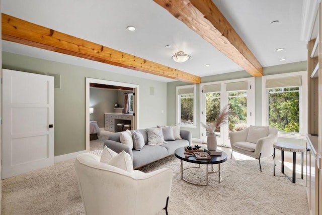 carpeted living room with beamed ceiling