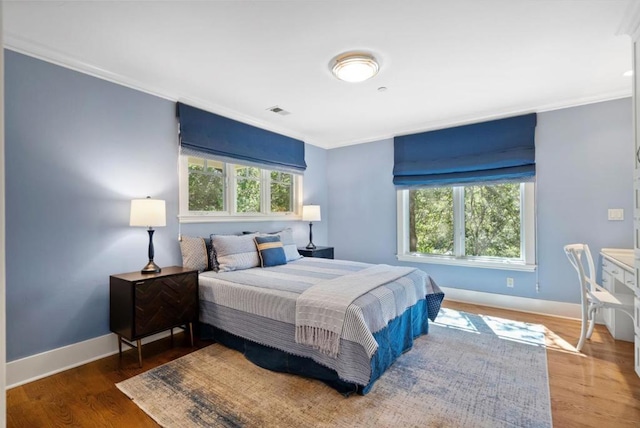 bedroom with dark hardwood / wood-style flooring and crown molding