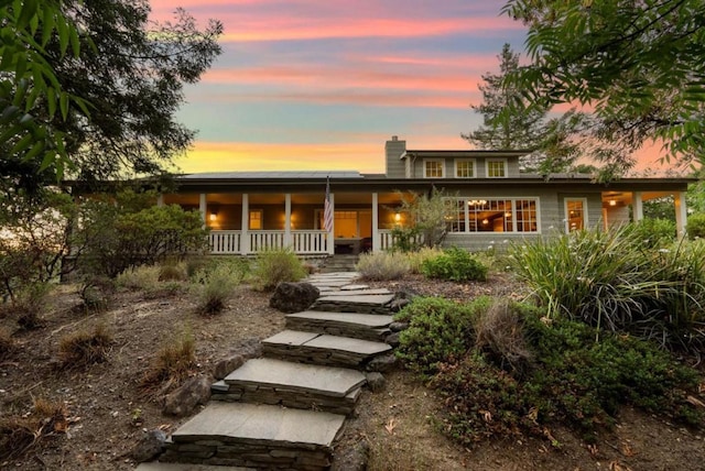 back house at dusk with covered porch