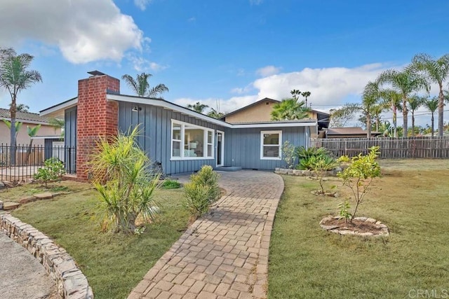 single story home featuring a front lawn