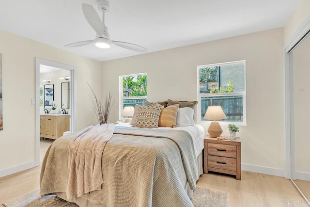 bedroom featuring ensuite bathroom, ceiling fan, and light wood-type flooring