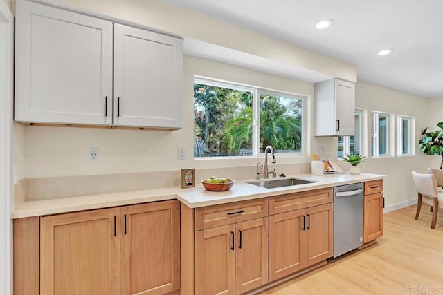 kitchen featuring sink, light hardwood / wood-style floors, white cabinets, and dishwasher