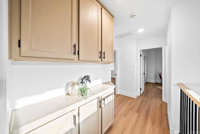 bar featuring light hardwood / wood-style floors and light brown cabinets