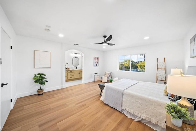 bedroom with ceiling fan, light hardwood / wood-style floors, and ensuite bath