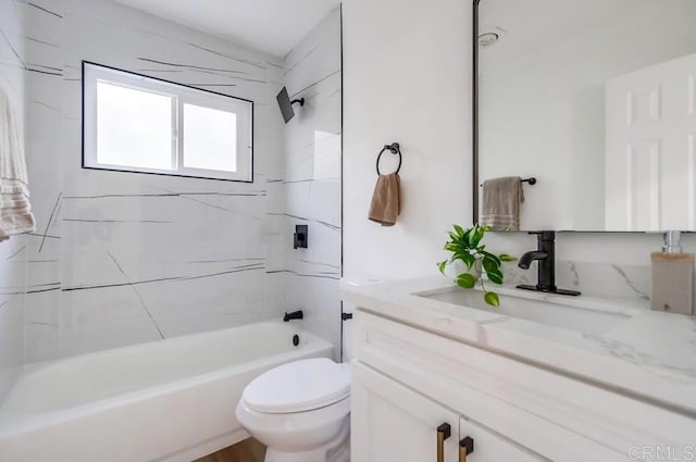 full bathroom featuring toilet, tiled shower / bath, and vanity