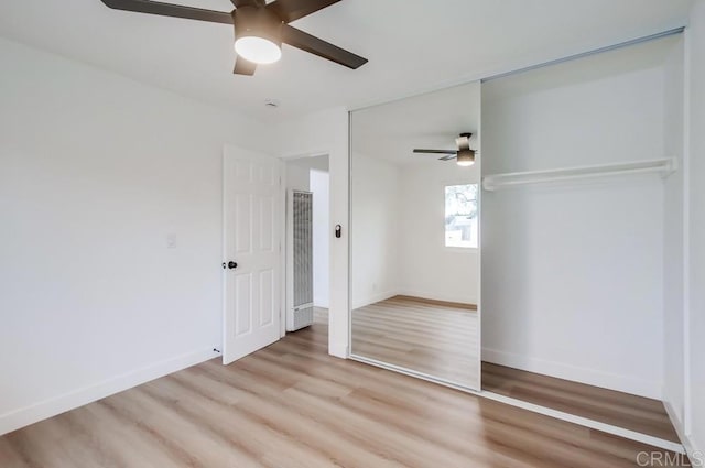 unfurnished bedroom featuring ceiling fan, a closet, and light hardwood / wood-style flooring