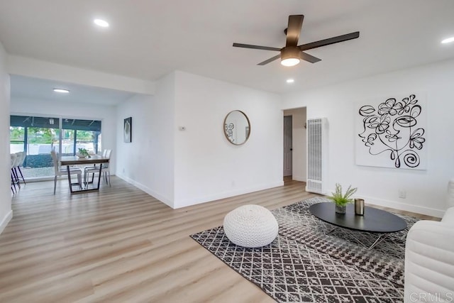 living room with ceiling fan and light hardwood / wood-style flooring