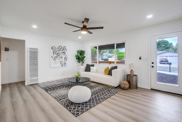 living room with ceiling fan and light wood-type flooring