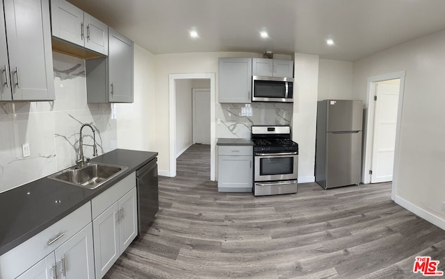 kitchen with sink, backsplash, dark hardwood / wood-style floors, and stainless steel appliances