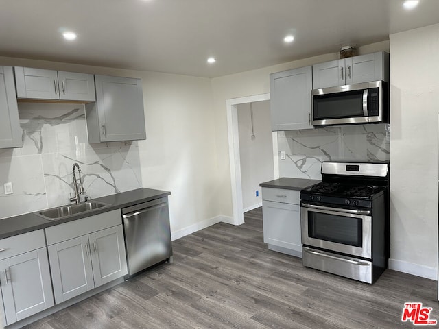 kitchen featuring stainless steel appliances, gray cabinetry, hardwood / wood-style floors, and sink