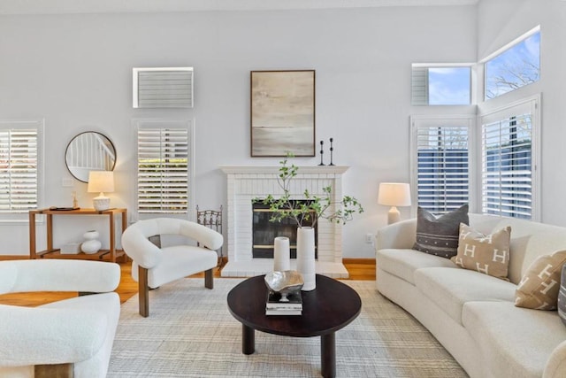 living room featuring wood-type flooring and a brick fireplace