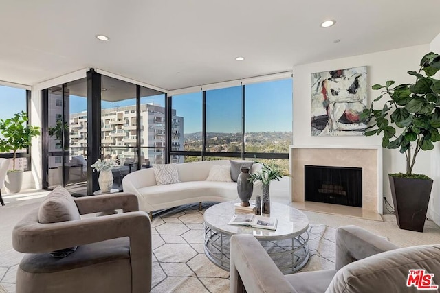 living room featuring a wall of windows, a healthy amount of sunlight, and a fireplace