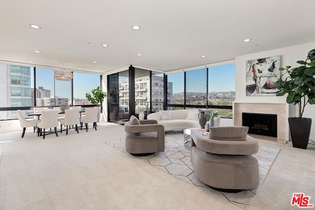 living room with a wealth of natural light, light colored carpet, and expansive windows