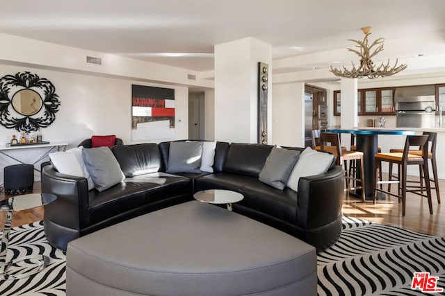 living room featuring light hardwood / wood-style flooring and an inviting chandelier