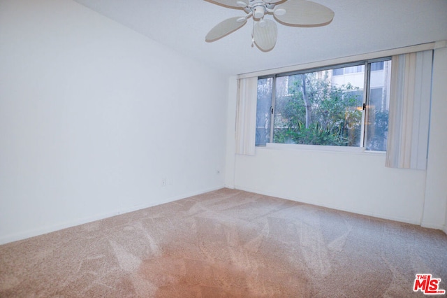 spare room featuring light carpet and ceiling fan