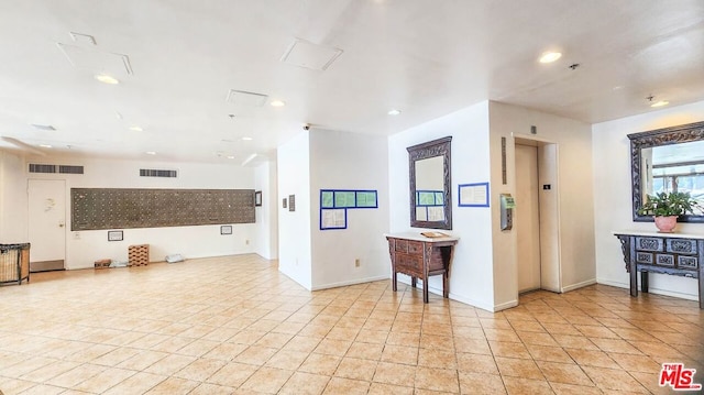 interior space featuring light tile patterned floors and elevator