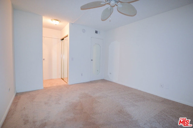 empty room with ceiling fan and light colored carpet