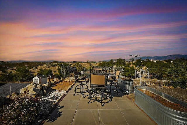 patio terrace at dusk featuring a mountain view