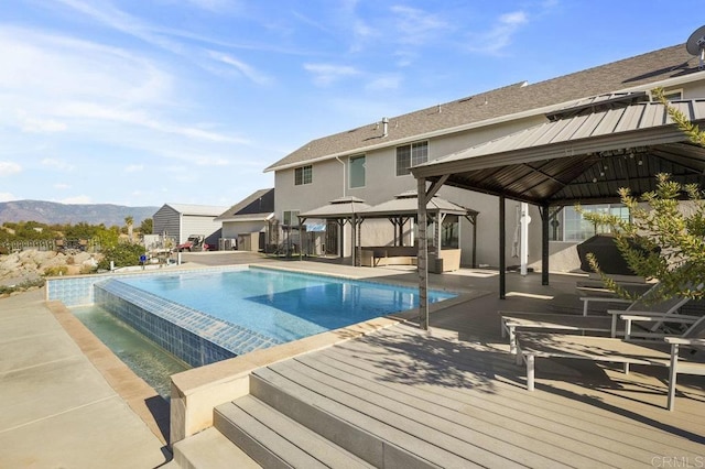 view of pool featuring a gazebo, a mountain view, and a patio