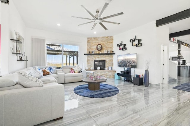 living room featuring ceiling fan and a fireplace