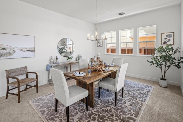 dining room with an inviting chandelier and carpet