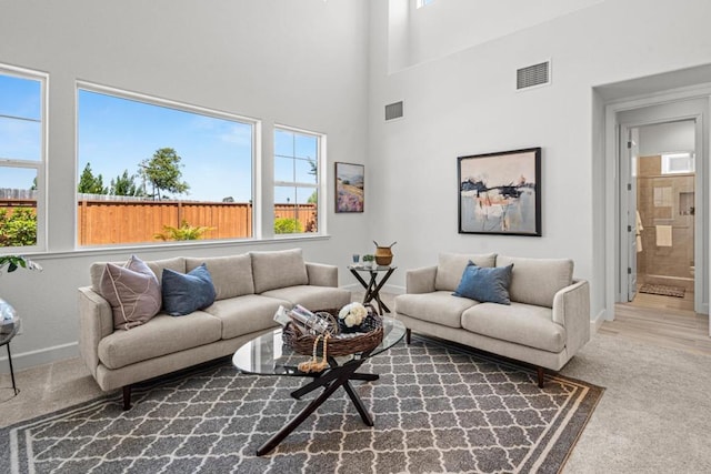 carpeted living room with a towering ceiling