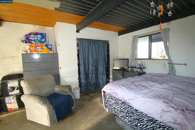 bedroom featuring concrete floors and beam ceiling