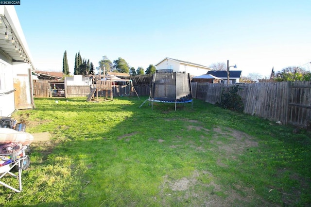 view of yard with a playground and a trampoline