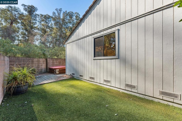 view of home's exterior with a jacuzzi and a yard