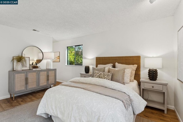 bedroom featuring dark hardwood / wood-style floors and a textured ceiling