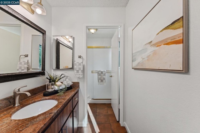 bathroom featuring vanity, a textured ceiling, tile patterned floors, and a shower with door