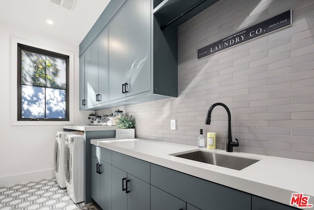 laundry room featuring cabinets, sink, washing machine and dryer, and light tile patterned flooring