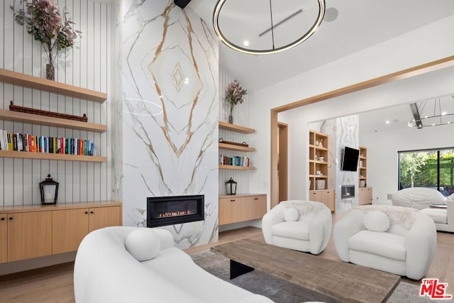 living room featuring light hardwood / wood-style flooring, lofted ceiling, and a fireplace