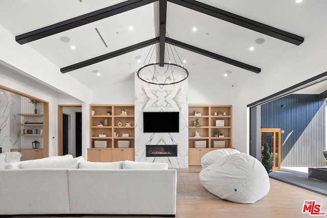 living room with a notable chandelier, light wood-type flooring, a premium fireplace, high vaulted ceiling, and beamed ceiling