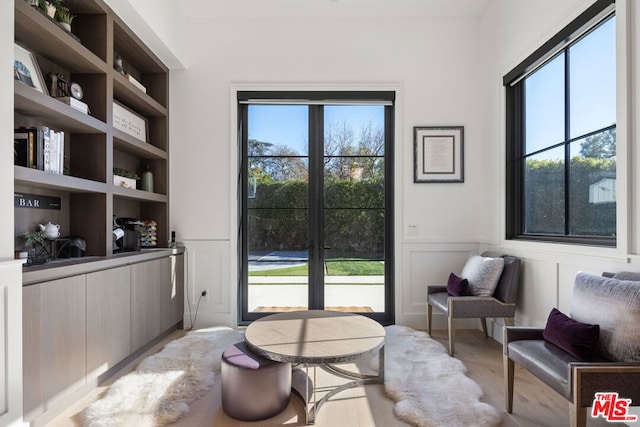 living area featuring light hardwood / wood-style floors, plenty of natural light, and built in features