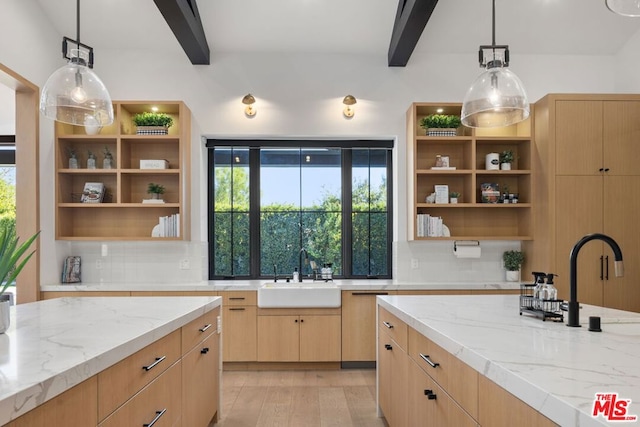 kitchen featuring sink, beam ceiling, light stone counters, and decorative light fixtures