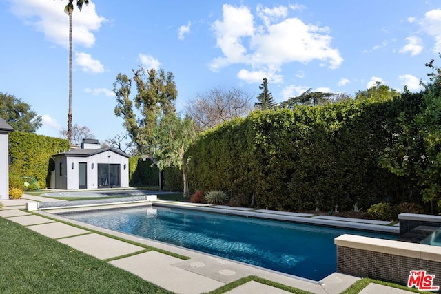 view of swimming pool featuring an outbuilding