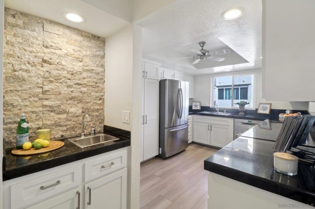 kitchen featuring white cabinetry, ceiling fan, stainless steel appliances, light hardwood / wood-style flooring, and sink