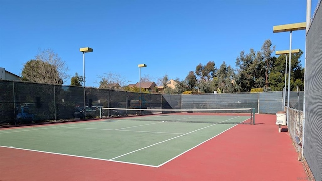 view of tennis court featuring basketball hoop