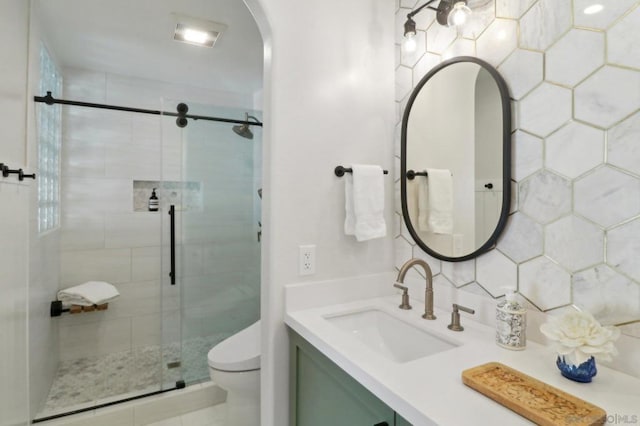 bathroom featuring toilet, vanity, an enclosed shower, and tasteful backsplash