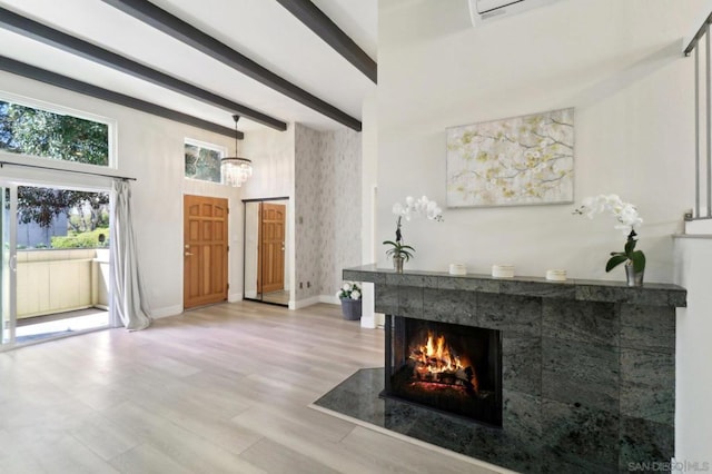 living room with light wood-type flooring, beamed ceiling, and a tile fireplace