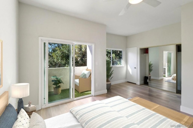 bedroom with ceiling fan, access to exterior, a closet, and hardwood / wood-style floors