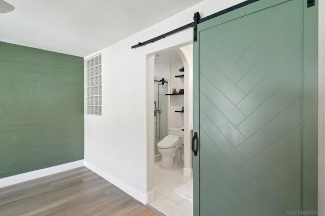 bathroom with a shower, wood-type flooring, and toilet