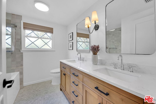 bathroom with toilet, a healthy amount of sunlight, an enclosed shower, and vanity