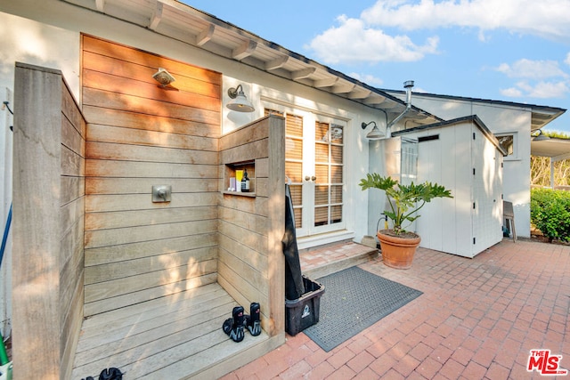 view of exterior entry with a patio