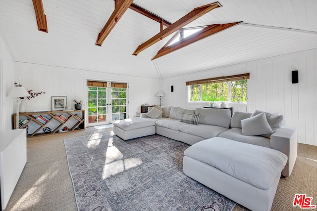 carpeted living room with french doors, plenty of natural light, beamed ceiling, and wooden walls