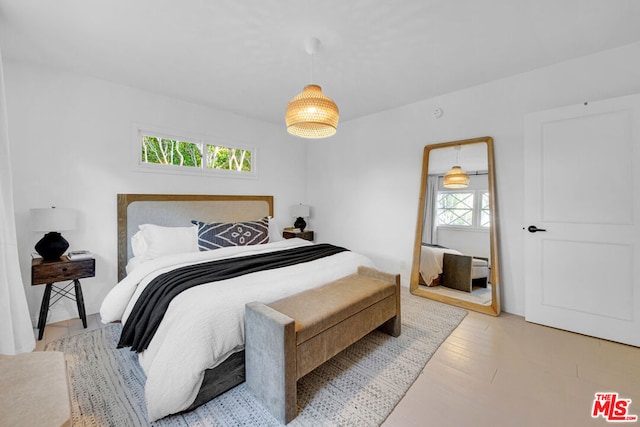 bedroom with light hardwood / wood-style floors and multiple windows