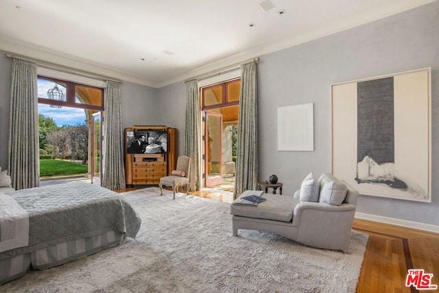 bedroom featuring wood-type flooring and ornamental molding